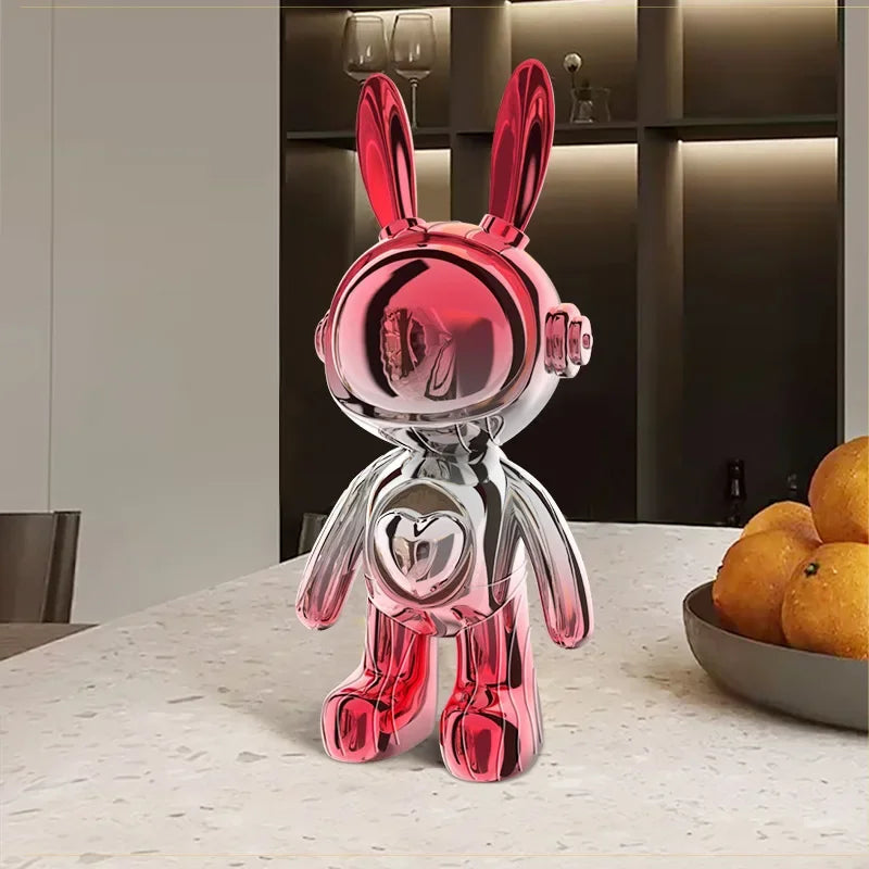 Sculpture déco de lapin astronaute en chrome rose et argent, au design futuriste et brillant, exposée sur une table contemporaine dans une cuisine moderne