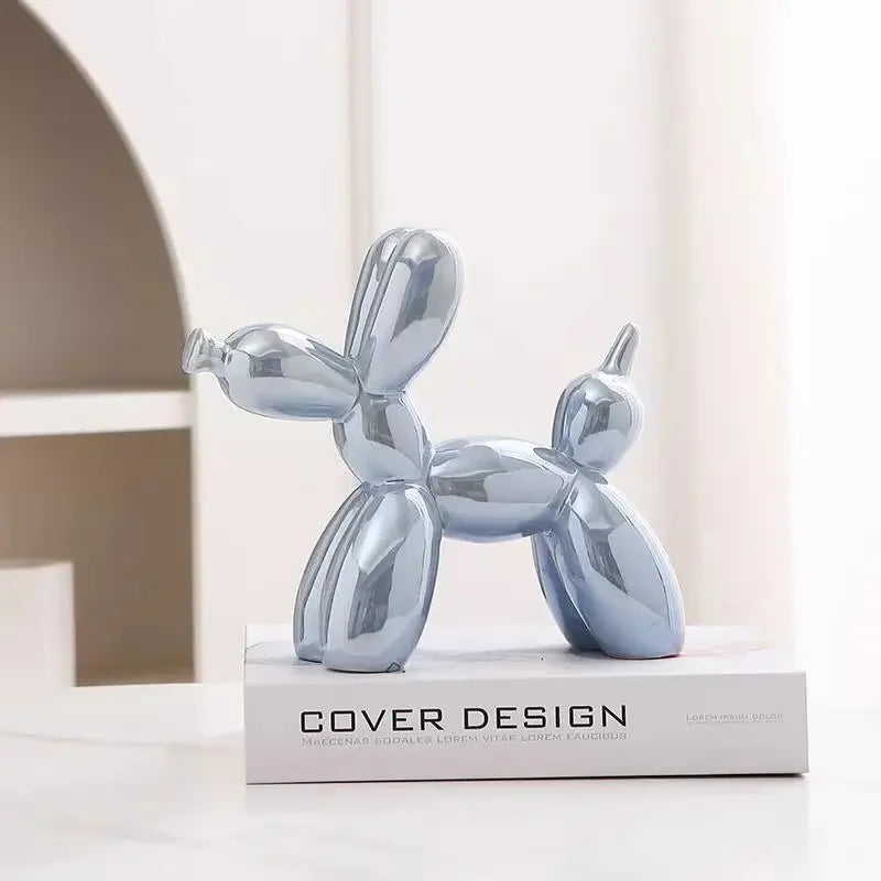 Sculpture ballon chien design argenté, inspirée de l’art contemporain, posée sur un livre de décoration dans un intérieur moderne minimaliste