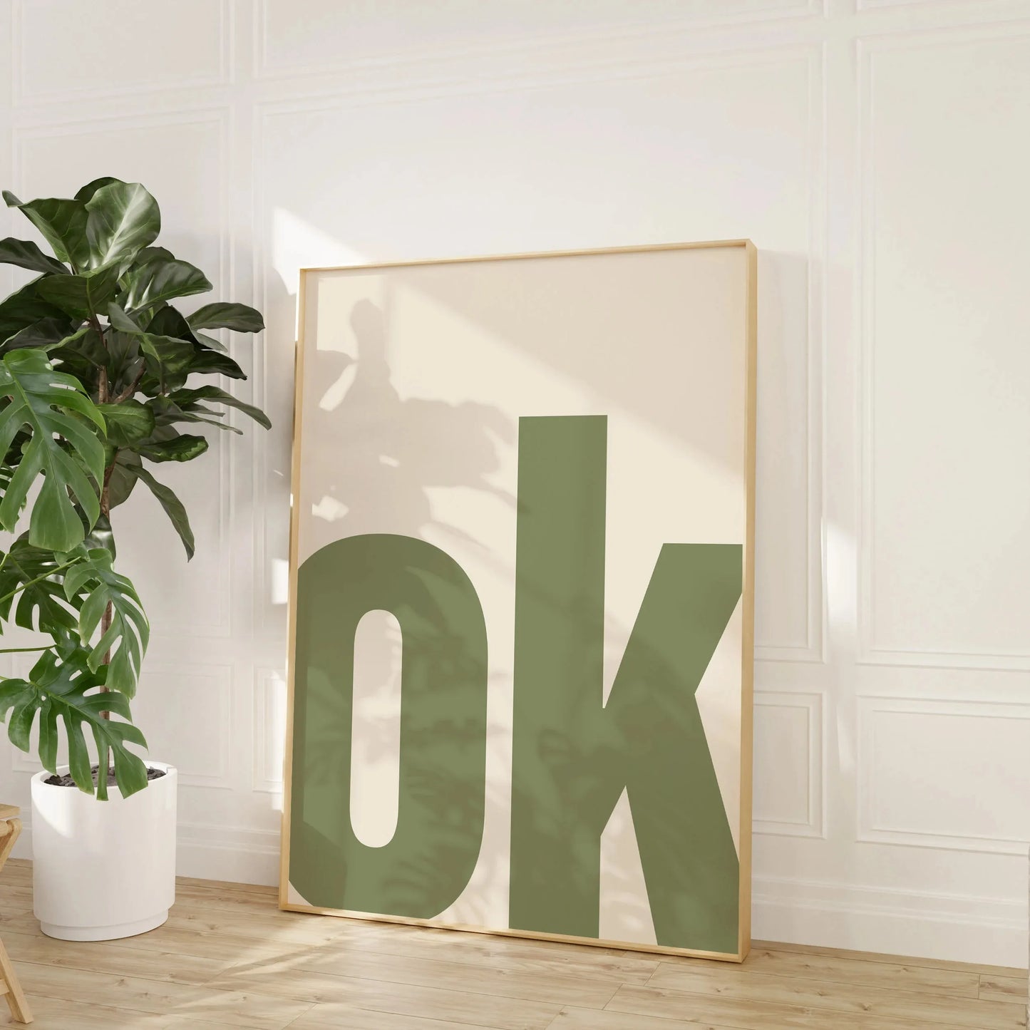 Affiche minimaliste avec le mot “OK” en lettres majuscules vert kaki sur fond crème, style épuré et design moderne pour une déco murale tendance.