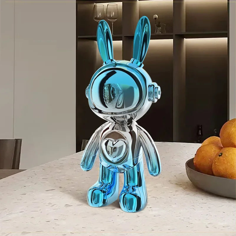 Figurine lapin design en résine chromée bleu ciel et argenté, style futuriste et pop art, posée sur une table en marbre dans un intérieur moderne