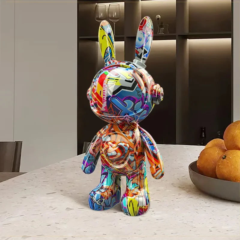 Figurine lapin astronaute au design graffiti multicolore, posée sur une table en marbre dans un intérieur contemporain chic