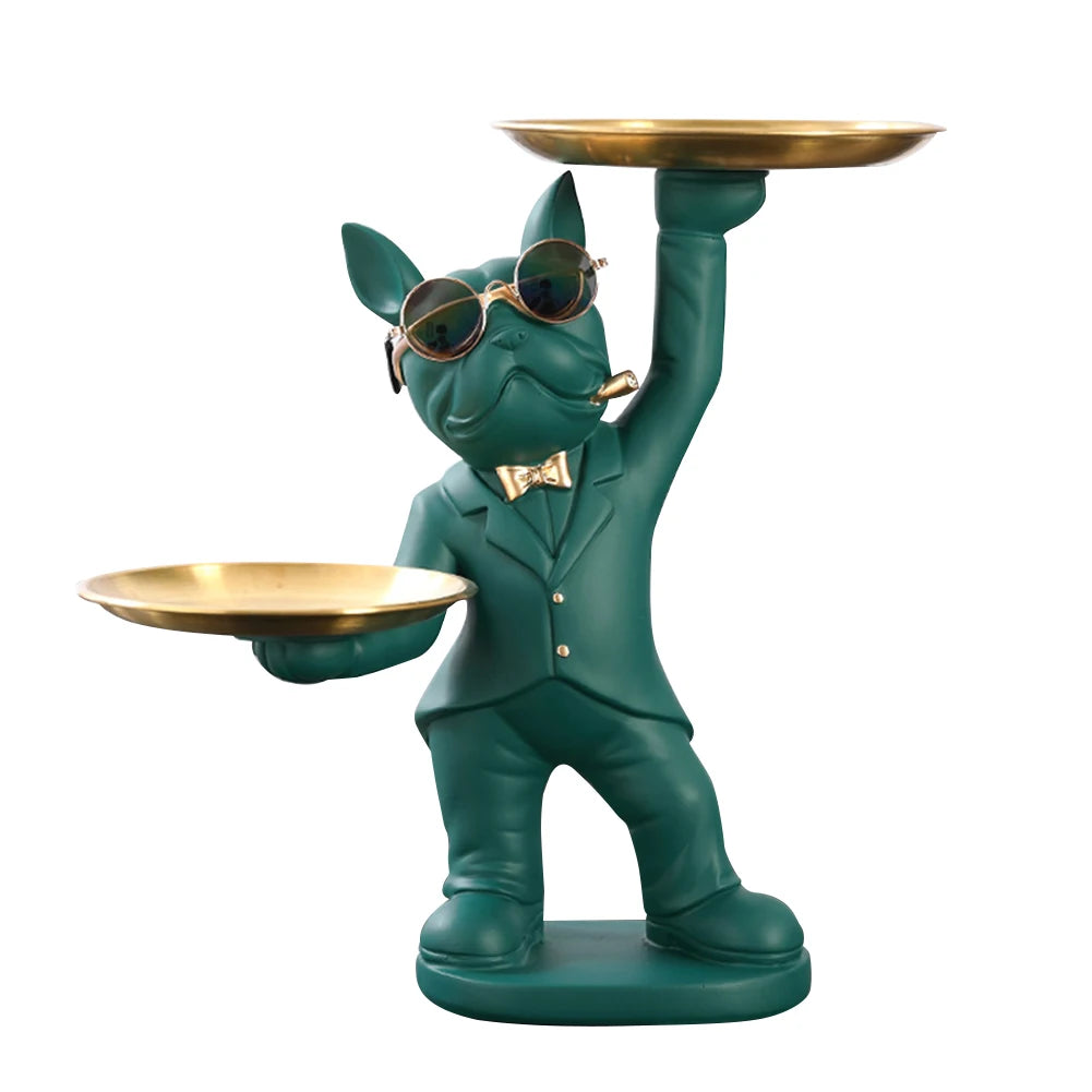 Statue de chien élégant vert foncé avec lunettes et nœud papillon, tenant deux plateaux dorés — objet déco original et pratique pour intérieur moderne.