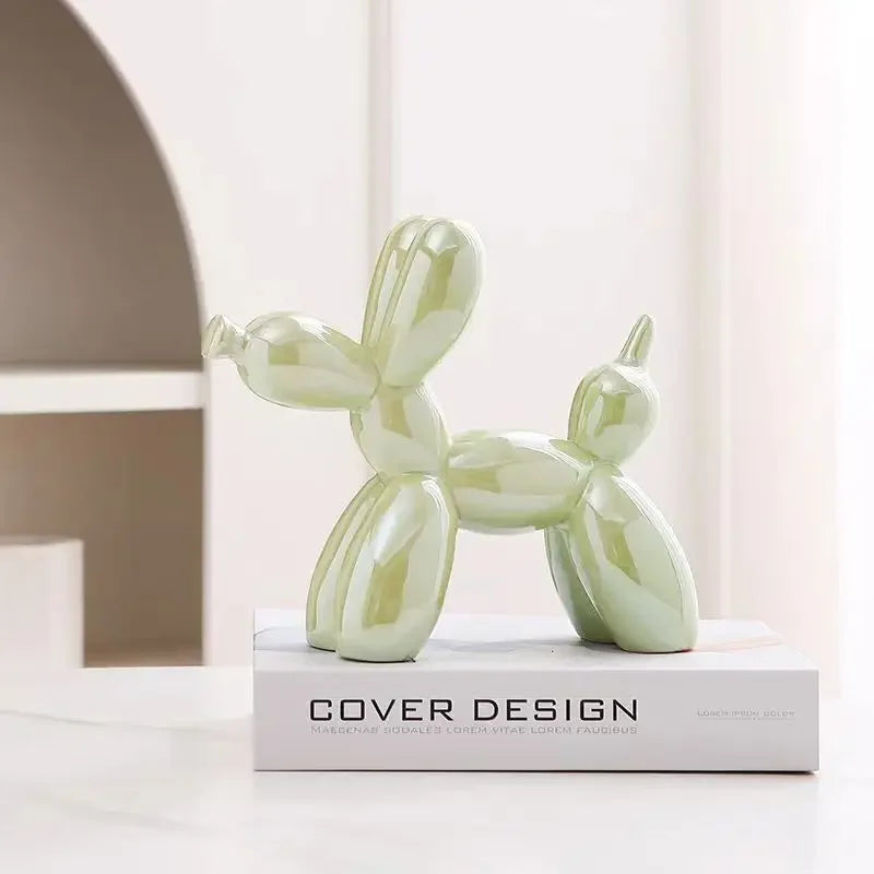 Sculpture chien ballon vert effet miroir, objet décoratif pop art sur un livre de design, dans une ambiance moderne et lumineuse