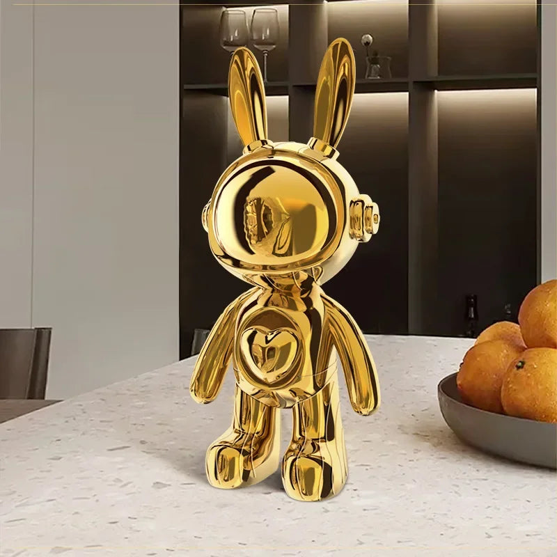 Sculpture design de lapin astronaute doré, finition brillante effet miroir, posée sur une table moderne dans un intérieur chic et minimaliste