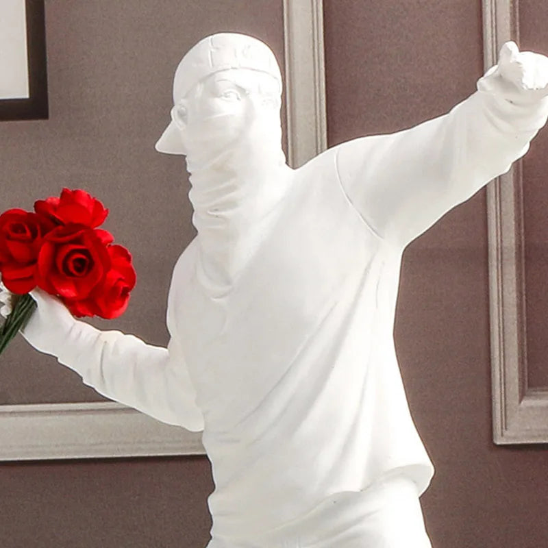 Statue blanche inspirée de Banksy représentant un manifestant lançant un bouquet de roses rouges, décor murale pop art au style contemporain et engagé