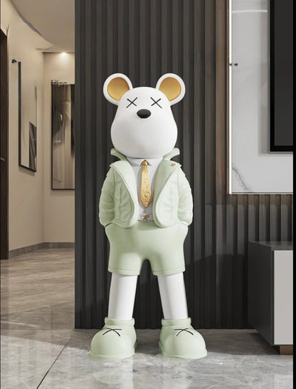 Sculpture décorative en forme d’ours blanc stylisé, vêtue d’une tenue verte pastel avec veste et cravate dorée, dans un intérieur moderne au style pop art