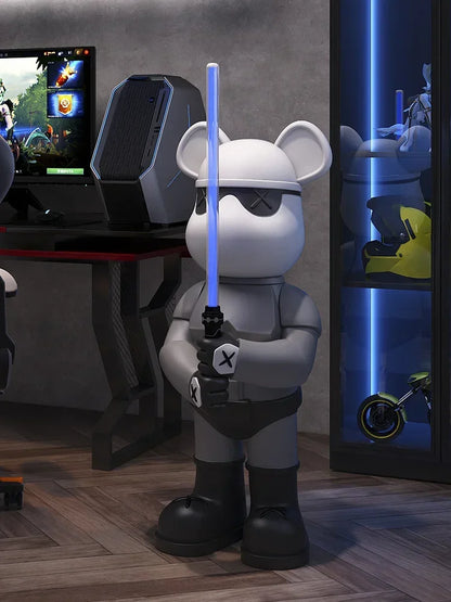 Statue de personnage ours blanc style pop art tenant un sabre laser bleu, posée dans une pièce gaming moderne avec setup PC RGB et éclairage néon futuriste