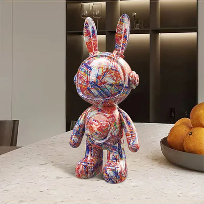 Sculpture décorative de lapin astronaute aux motifs graphiques multicolores façon gribouillage, posée sur une table de cuisine desig